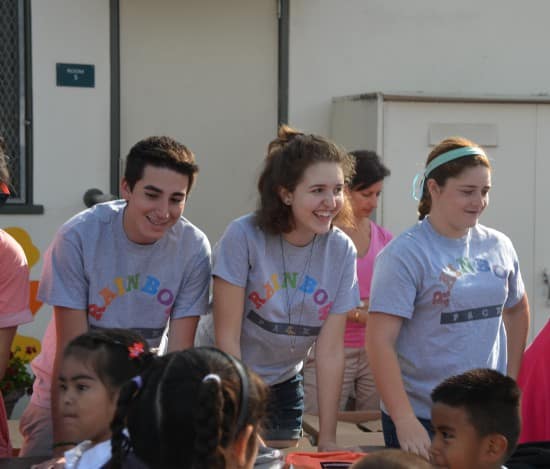 Service with a smile. Riley and two Rainbow Pack volunteers at a backpack giveaway (courtesy).