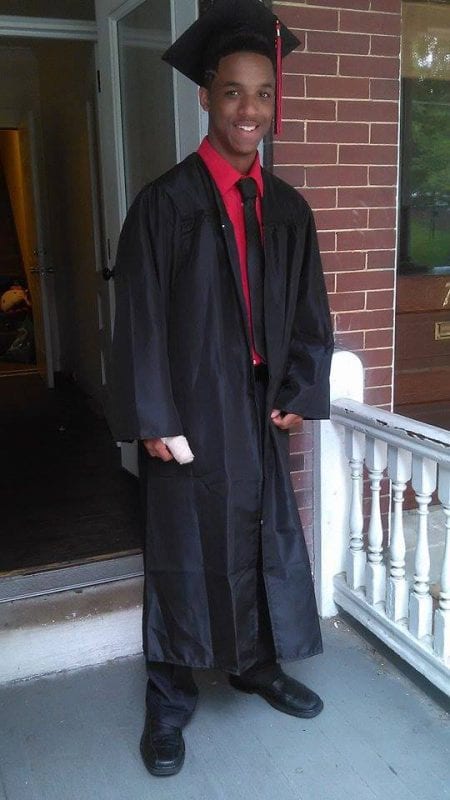 A smiling African American boy in cap and gown
