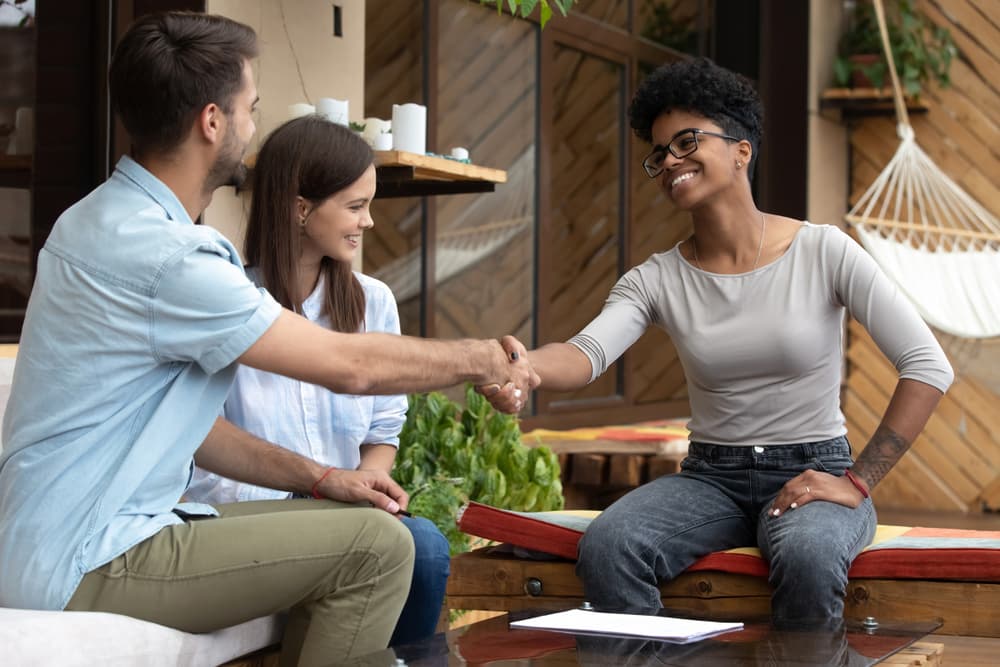 couple shaking hands with real estate agent