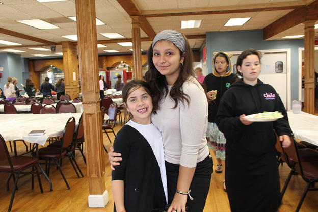 a girl with a woman at a car donation event