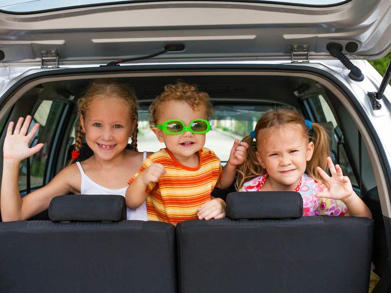 summer-family-road-trip-three-children-in-back-seat