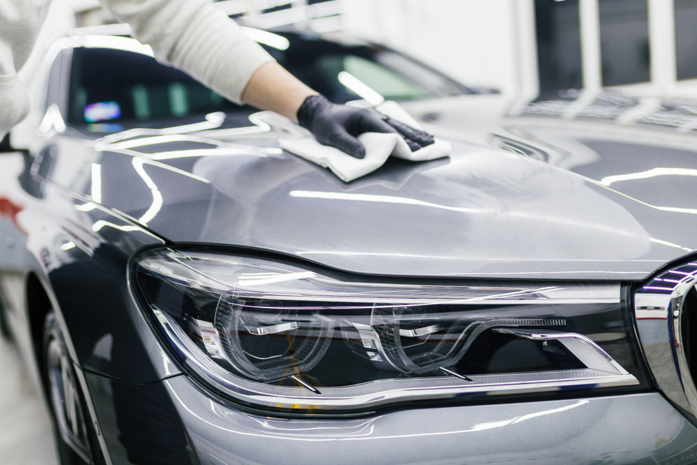 man polishes silver car