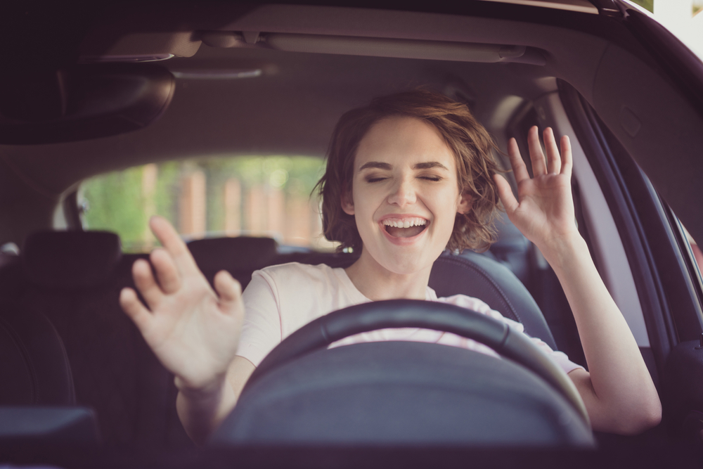 woman sings gestures in brown car