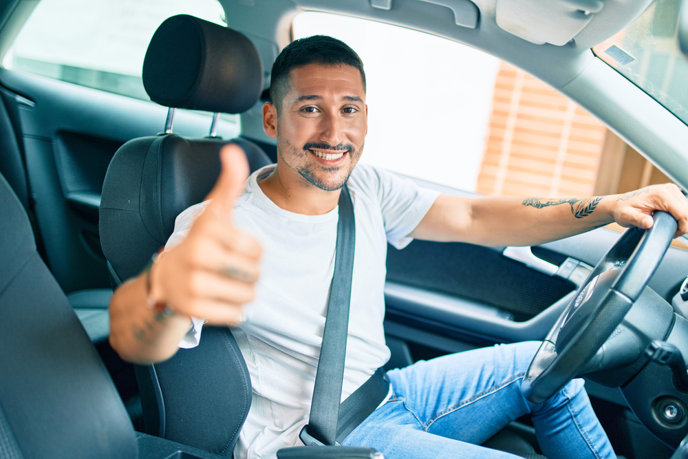 confident thumbs up shy male driver in tshirt and jeans