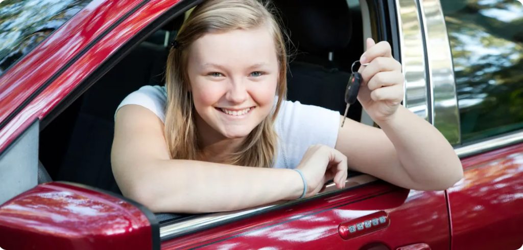 new girl driver holds key looks out window red car after finishing driver's ed