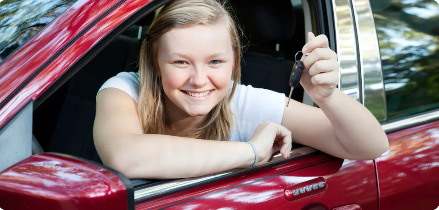 new girl driver holds key looks out window red car after finishing driver's ed