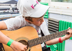 Young boy learning how to play the guitar
